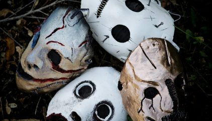 a group of three painted masks laying on the ground